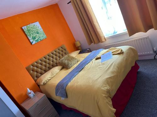 克劳利Quick Stop Night Stay - Gatwick的一间卧室配有一张橙色墙壁的床