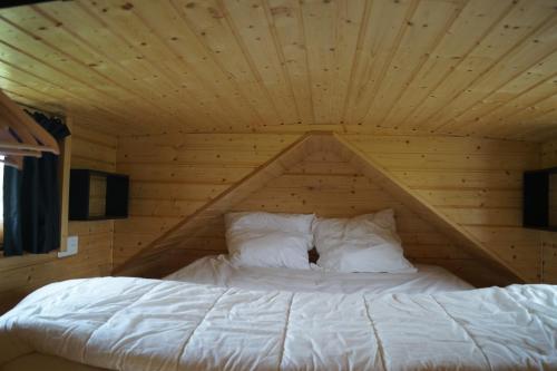 La BoissièreSpa & Bain Nordique - Tiny house à la campagne的木天花板的客房内的一张床位