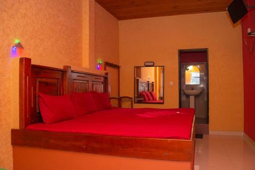 库鲁内格勒Hotel Janara的一间卧室配有一张带红色床单和镜子的床