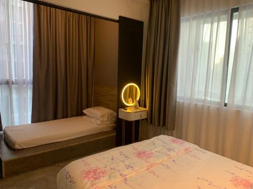 马六甲lmperio Residence Melaka - Private Indoor Hot Jacuzzi的一间卧室配有两张床和一盏灯。