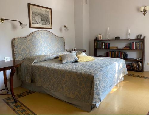 巴尼－迪卢卡Burlamacchi Villas的一间卧室设有一张床和一个书架