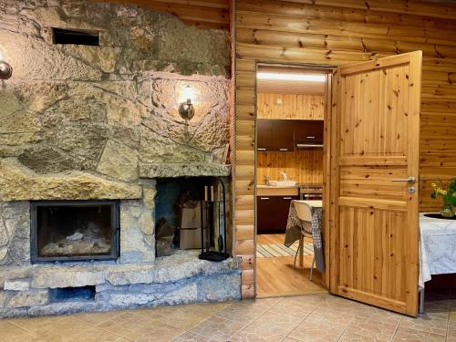 KurdlaLaimjala Guesthouse with a Cozy Lounge and Terrace的一间客厅,客厅内配有石头壁炉。