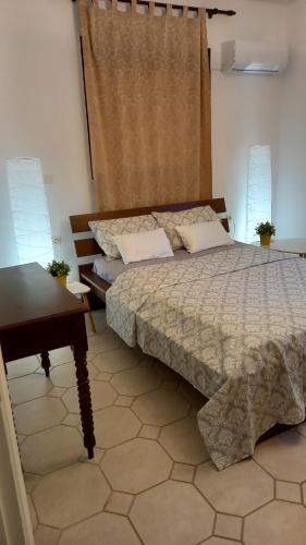 ZipárionISLAND HOME的卧室配有床、桌子和窗户。