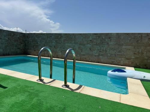 维拉Ático con piscina privada vistas al mar.的一个带两个金属栏杆的游泳池