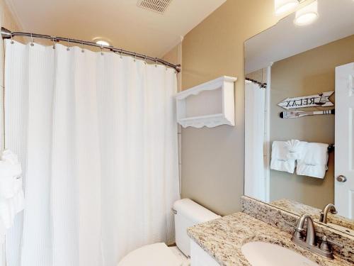 泰比岛Silver Shores Unit 8的一间带卫生间、水槽和镜子的浴室