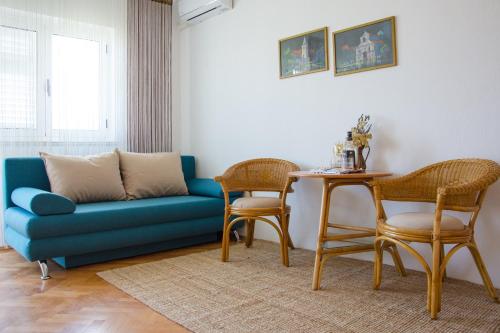 帕格Apartmani Ina Pag的客厅配有蓝色的沙发和桌子