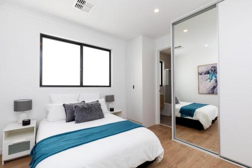 PlymptonLuxury private ensuite room close to Airport,City, Genelg Beach的一间卧室配有一张床和镜子