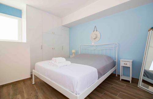 伊西翁Laconian Collection Cosy House in the heart of Gytheio的一间卧室设有一张床和蓝色的墙壁