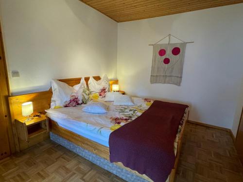 拉茨查赫·奥伯登弗Apartments Wrolich的一间卧室配有一张带鲜花的大床