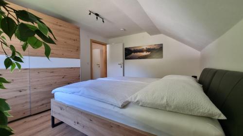 巴德小基希海姆Ferienwohnungen Rabensteiner的一间卧室设有一张带木墙的大床