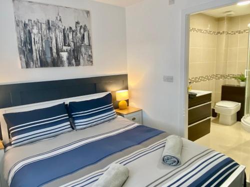 本莱赫Apartment 3 Benllech with Sea views的卧室内的一张带蓝色和白色枕头的床