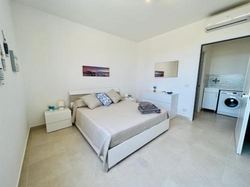 拉古萨码头Atmosfere di mare的一间白色卧室,配有床和洗衣机