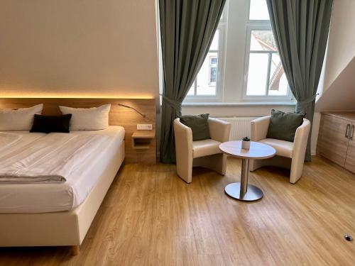 韦特海姆Hotel Bronnbacher Hof的酒店客房带一张床、一张桌子和椅子