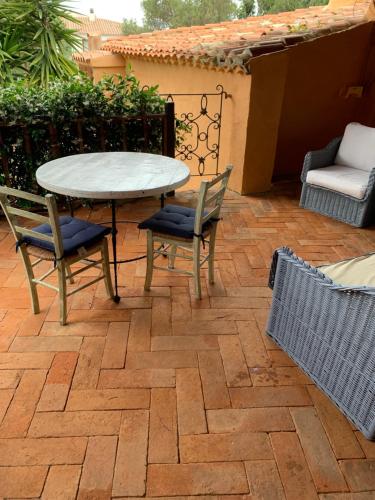 切尔沃港L'Olivastro的砖砌庭院内带桌椅的庭院