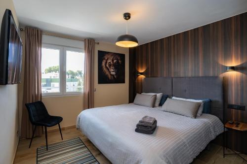 多列毛利诺斯Los Riscos Luxury Apartment - Torremolinos的一间卧室配有一张大床和一把椅子