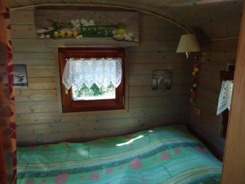 HermelinghenRoulotte dans un cadre verdoyant的小木屋内的一张床位,设有窗户