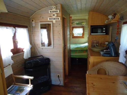 HermelinghenRoulotte dans un cadre verdoyant的一间小房间,一间小房子里的厨房和一间卧室