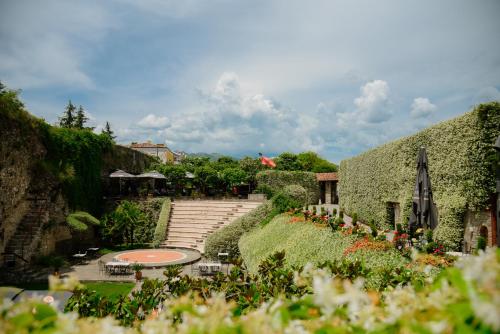 爱尔巴桑里尔斯堪皮酒店的花园设有楼梯和雨伞,种有鲜花