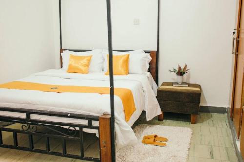 基苏木Kwe Decasa的一间卧室配有一张带橙色和白色枕头的大床