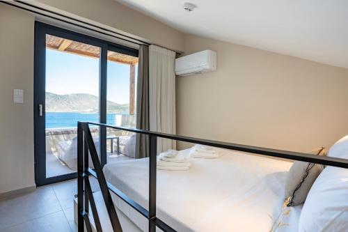 阿尔米洛波塔莫斯Elivia Boutique Suites的一间卧室设有一张床和一个海景阳台