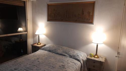 布宜诺斯艾利斯Buenos Aires - La Boca的一间卧室配有一张床和两张台灯。
