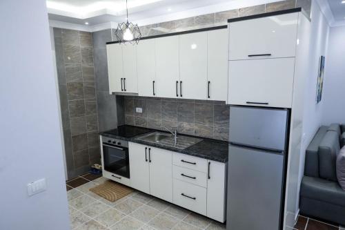 维利波吉Fishta Apartments Q5 33的厨房配有白色橱柜和水槽