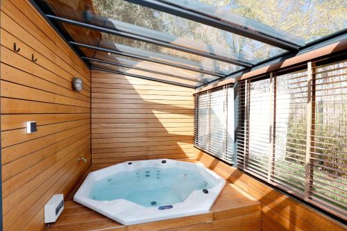 阿维尼翁Le mazet des amants, cabane en bois avec jacuzzi privatif的一个带窗户的客房内的按摩浴缸