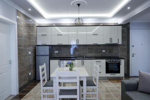 维利波吉Fishta apartments Q5 32的厨房配有白色橱柜和桌椅