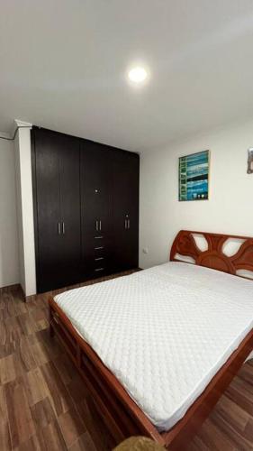 ChiquinquiráApartamento para turismo en Chiquinquirá的一间卧室配有一张大床和黑色橱柜。