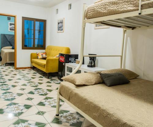 帕纳哈切尔Atitlan´s House的一间卧室配有两张双层床和一张黄色椅子