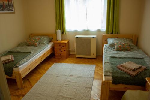 埃格尔Foxy Apartman的一间卧室设有两张单人床和一个窗户。