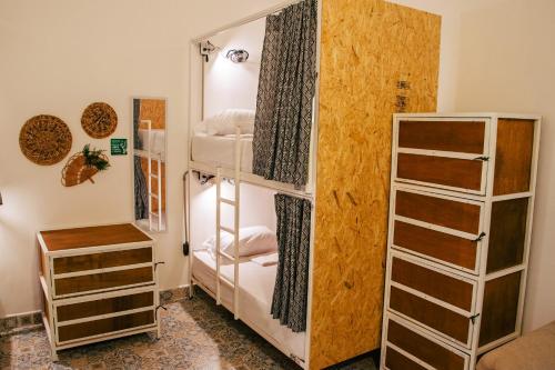 麦德林Cordova Hostel Medellin的客房设有三张双层床和衣柜。