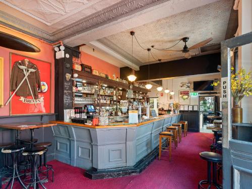 悉尼Lord Wolseley Hotel的餐厅内的酒吧,铺着粉红色的地毯