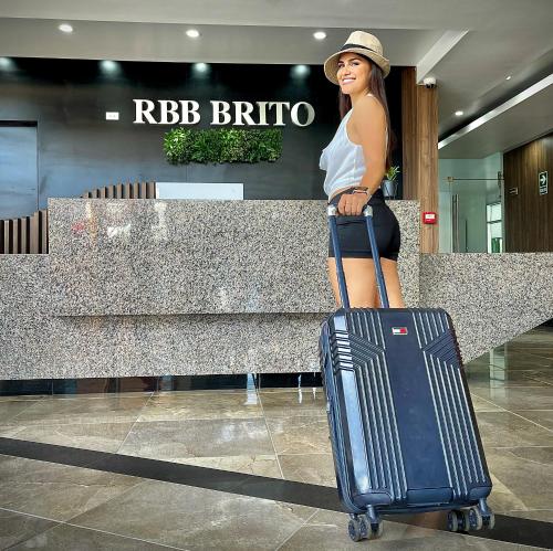 塔拉波托RBB BRITO HOTEL的女人在机场里拿着行李站着