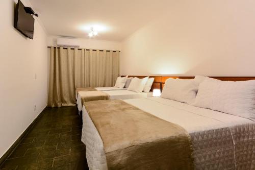 阿瓜斯迪林多亚Hotel Fazenda Aguas de Lindoia的酒店客房设有两张床和电视。