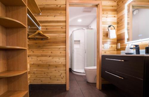 西基隆拿Sunrise Valley Suite的一间带卫生间和木墙的浴室