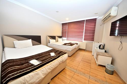 伊斯坦布尔奥廷博艺努兹家庭酒店的酒店客房设有两张床和窗户。