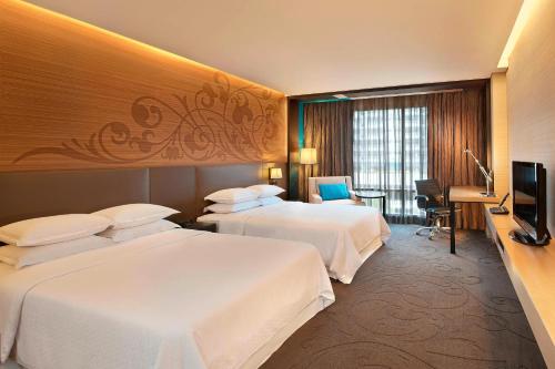 曼谷素坤逸 15 号喜来登曼谷四点酒店的酒店客房设有两张床和电视。