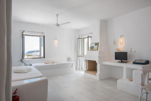 圣玛丽亚Aeraki Villas的白色的客房配有两张床和电视。