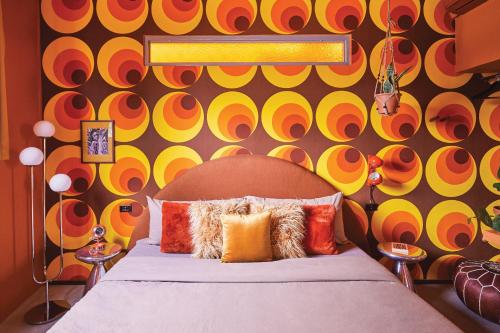圣胡安MOOD HAUS by DW的一间卧室设有一张床和色彩缤纷的墙壁