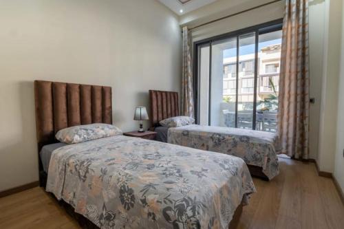卡萨布兰卡Appartement spacieux avec piscine à Dar Bouazza - Casablanca的一间卧室设有两张床和窗户。