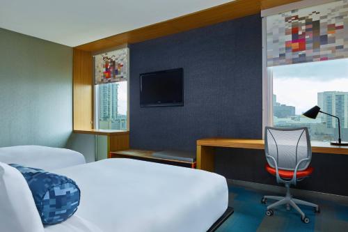 休斯顿休斯敦画廊雅乐轩酒店的一间卧室配有一张床、一张书桌和一台电视。