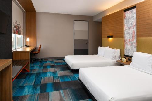 列克星敦莱克星顿雅乐轩酒店的酒店客房设有两张床和电视。