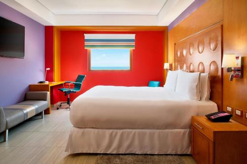 坎昆雅乐轩坎昆酒店的酒店客房带一张大床和一把椅子