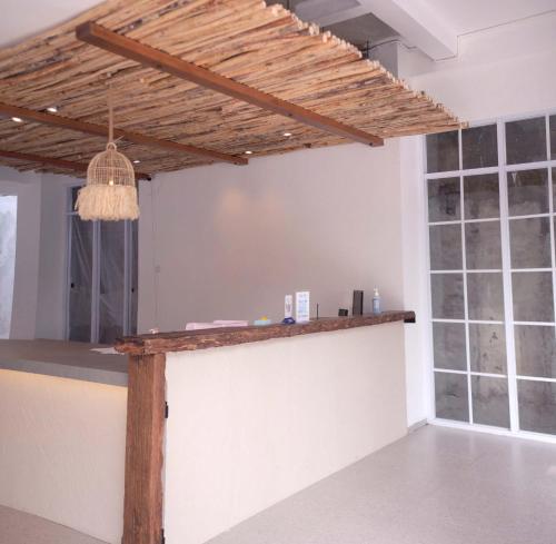 万隆Little Mykonos的一间酒吧,位于一间拥有木制天花板的房间内