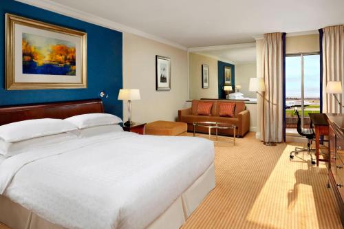 希灵登喜来登伦敦希思罗天际线酒店的酒店客房设有一张大床和一张沙发。