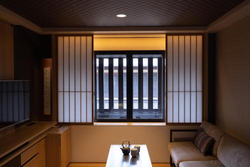 京都三井花园饭店 京都新町别邸的带沙发和窗户的客厅