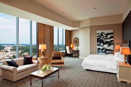 格林斯伯勒格林斯伯罗喜来登酒店的酒店客房配有床、沙发和桌子。