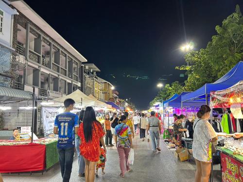 那空拍侬府Los Inn Nakhon ลอส อินน์ นคร的一群人晚上在市场里走来走去