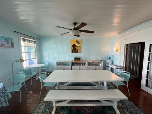 奥克布拉夫斯Inkwell Beach Cottage的一间配备有白色桌椅的用餐室